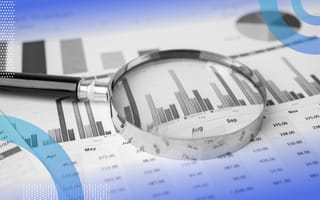Inferential statistics image of a magnifying glass sitting on top of a bar graph