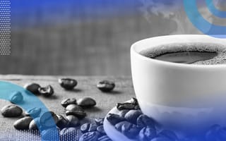 Java image of a full coffee cup on a saucer. There are coffee beans on the table.