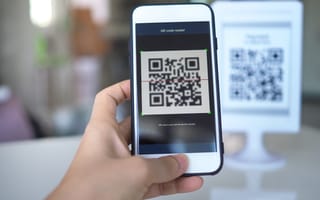 A person captures a QR code on their iPhone.