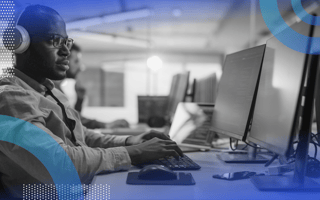 Reinforcement learning image of a man sitting at a desktop computer wearing headphones and working intently,