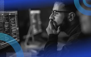 What Is a Software Requirement Specification? Software requirement specification image of a bearded man wearing glasses holding his chin and looking at a screen as though studying or reading something