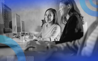 Web development image of two women looking at a computer screen together and laughing