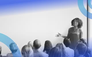 Employee training image of a woman standing in front of a group of people speaking and gesturing