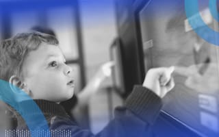 A child interacts with a touchscreen monitor