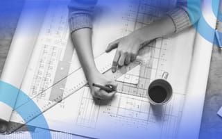 An architect works on plans with a square and triangle with a cup of coffee
