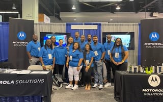 Part of the Motorola Solutions team posing at a company booth.