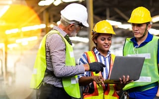 A construction crew looking at a laptop.