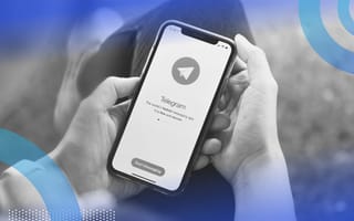 Hands hold a smartphone displaying the Telegram logo