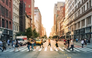 Pedestrians cross an NYC street at golden hour