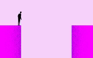 A person standing on one endo of a large gap looking down into it.