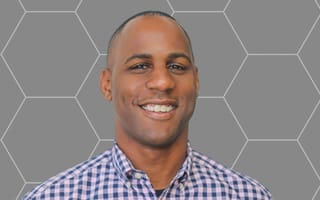 Nex Cubed’s CEO Marlon Evans poses for a photo against a gray background.