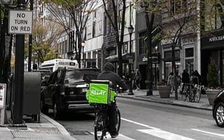 A Relay Delivery courier bikes through the city.