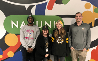 four employees standing in front of Nasuni mural