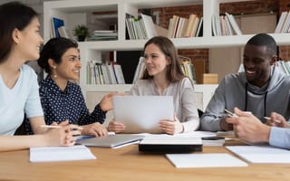 Four people sit around a table with papers