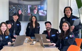 The Philo design team clusters in a conference room with Sandy Micone at the center