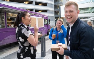 Imprivata teammates laughing together beside a food truck