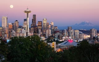 The Seattle skyline with a full moon and Mt. Rainier in the backdrop