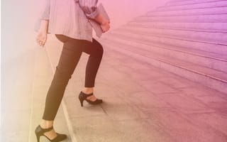 Photo of a woman in sensible heels and business casual clothes walking up stairs. There's a golden and pink gradient overlay.
