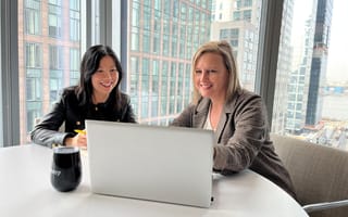 Yang Lu and Annette Hater work on a laptop together.