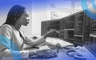 A programmer works on code on multiple screens