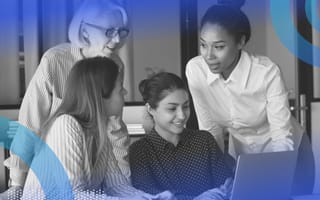 Women working together at a desk. Mentoring and advocating for women can help attract women to tech and keep them there.