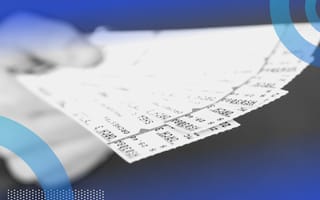 A hand holds concert tickets