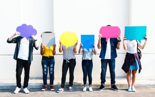 A group of people holding paper cutouts of speech bubbles