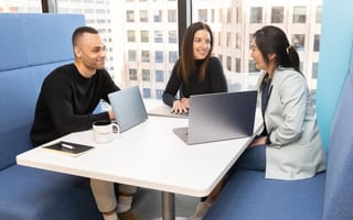 three coworkers at a table chatting
