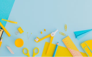 Yellow and blue desk objects (pencils, paperclips, notepads, etc.) against a blue backdrop