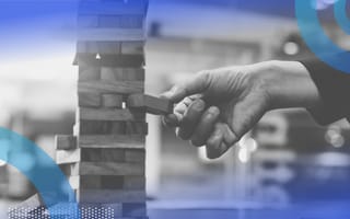 A hand removes a piece from a jenga tower