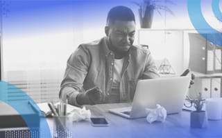 A man scowling at his computer. Managing stress of a job you hate is important.