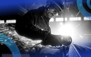 Industrial worker cutting metal, sparks flying