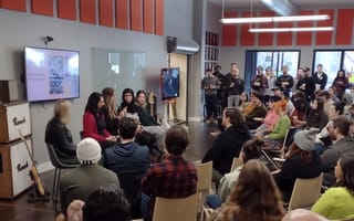 Reverb employees gathered around to watch a panel discussion during Ensemble Week.