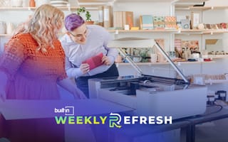 Two people use a Glowforge 3D printer for a project.