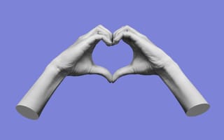 Two hands make a heart symbol in front of a purple background.