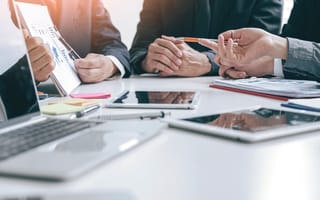 Team members sit around a conference table discussing marketing strategy.