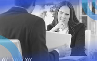A woman looking askance at a computer. Recruiters should spot fake talent during a job interview.