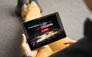 A person holds a tablet preparing to hit play on a live video stream.