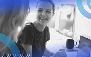 A woman smiling at work. Make work more joyful by getting an office BFF and engaging in chit-chat.