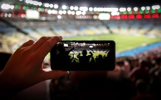 An influencer takes photos at a sporting event.