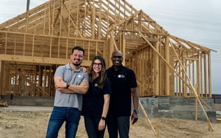 Members of the NewHomesMate executive team pose for a photo in front of an under-construction home.