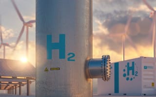 7 Top Alternative Energy Companies A hydrogen energy storage system sits in the foreground with solar panels and wind turbines in the background to represent alternative energy.
