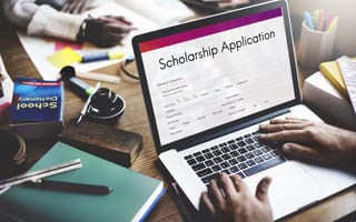 A scholarship application is open on a laptop screen.