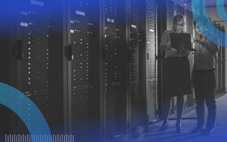 Two people converse near a row of servers