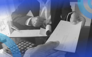 Someone handing someone a check. Companies are being more frugal with compensation packages in the current economic climate.
