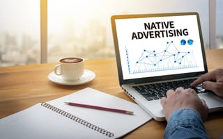 Hands type on a laptop with text on the monitor that says native advertising.