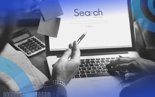 A hand with a pen points at a search engine on a laptop screen