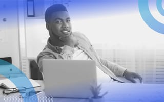 a Black businessperson at a computer. Hiring Black-owned vendors and visiting Black-owned businesses can help build wealth in the Black community.