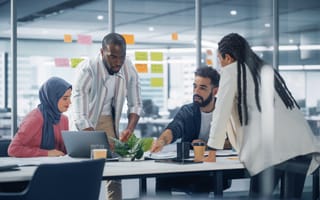 Four people in a discussion around a conference table.