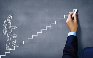Hand draws on chalkboard a man in suit climbing stairs